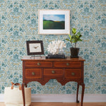 Piedmont (Mist) wallpaper with tan foxes, dusty deep green flora, cream accents on a light gray blue background