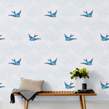 Daydream (French Blue) features a pattern of flying birds and floating clouds in shades of blue on white