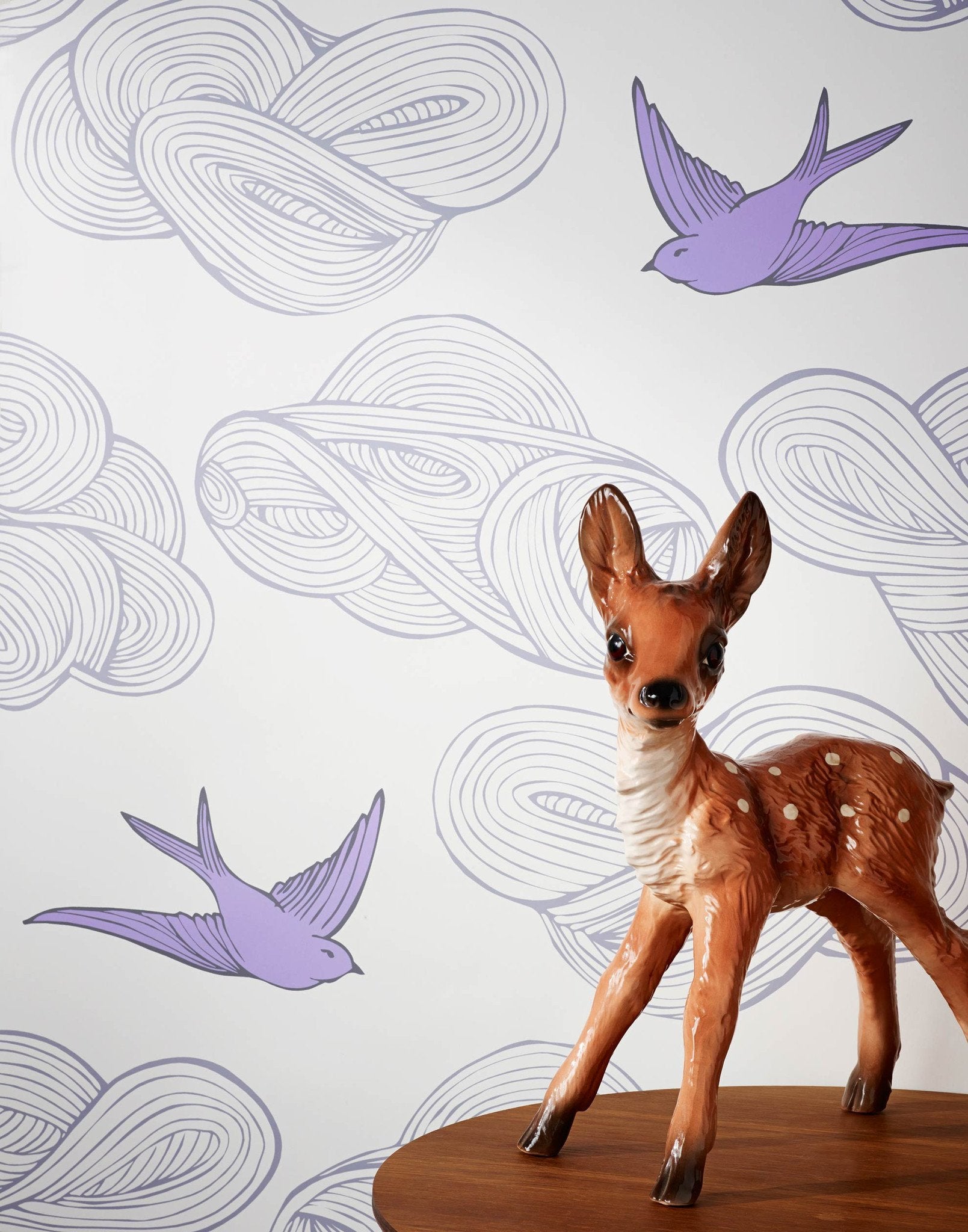 Daydream (Lilac) features a pattern of flying birds and floating clouds in purple and gray on white