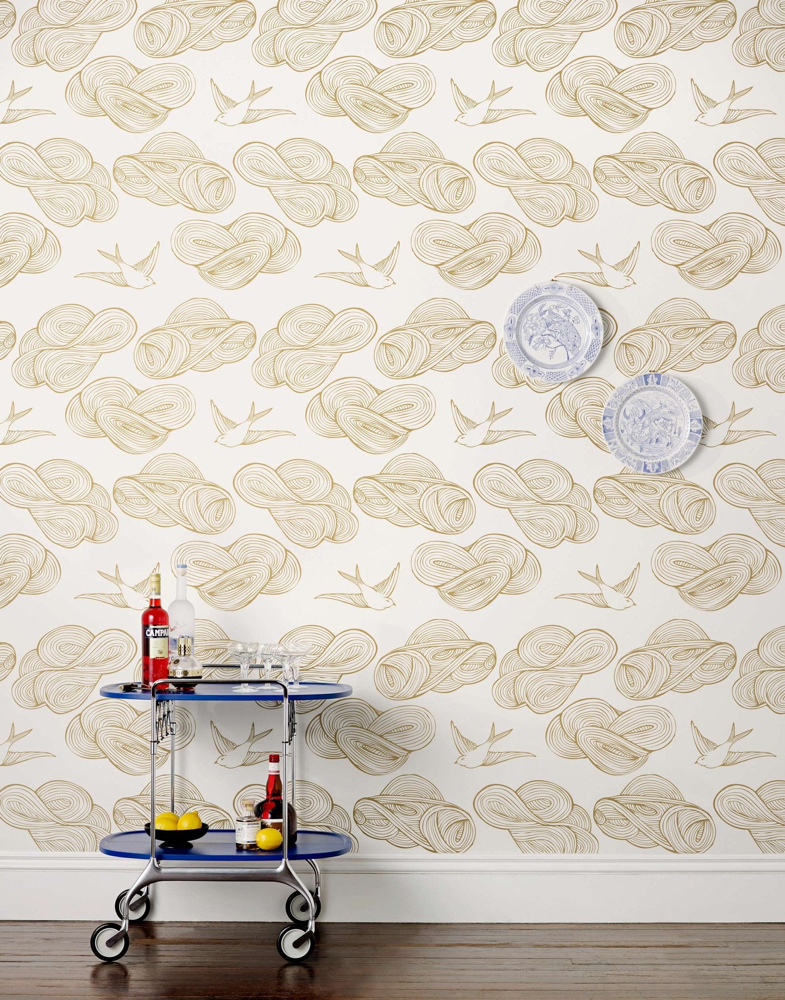 Daydream (Gold) features a pattern of flying birds and floating clouds in metallic on white