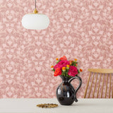 Symmetry wallpaper is a stylized floral wallpaper and designed in linocut style by Katharine Watson for Hygge & West | Dark pink and light pink flowers on a rose pink wallpaper background.