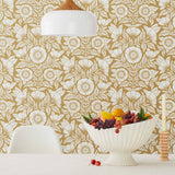 Conservatory wallpaper featuring stylized petals and leaves dervived from a block-print technique was designed by Katharine Watson for Hygge & West. Featuring white flowers on and ochre / yellow mustard wallpaper background.