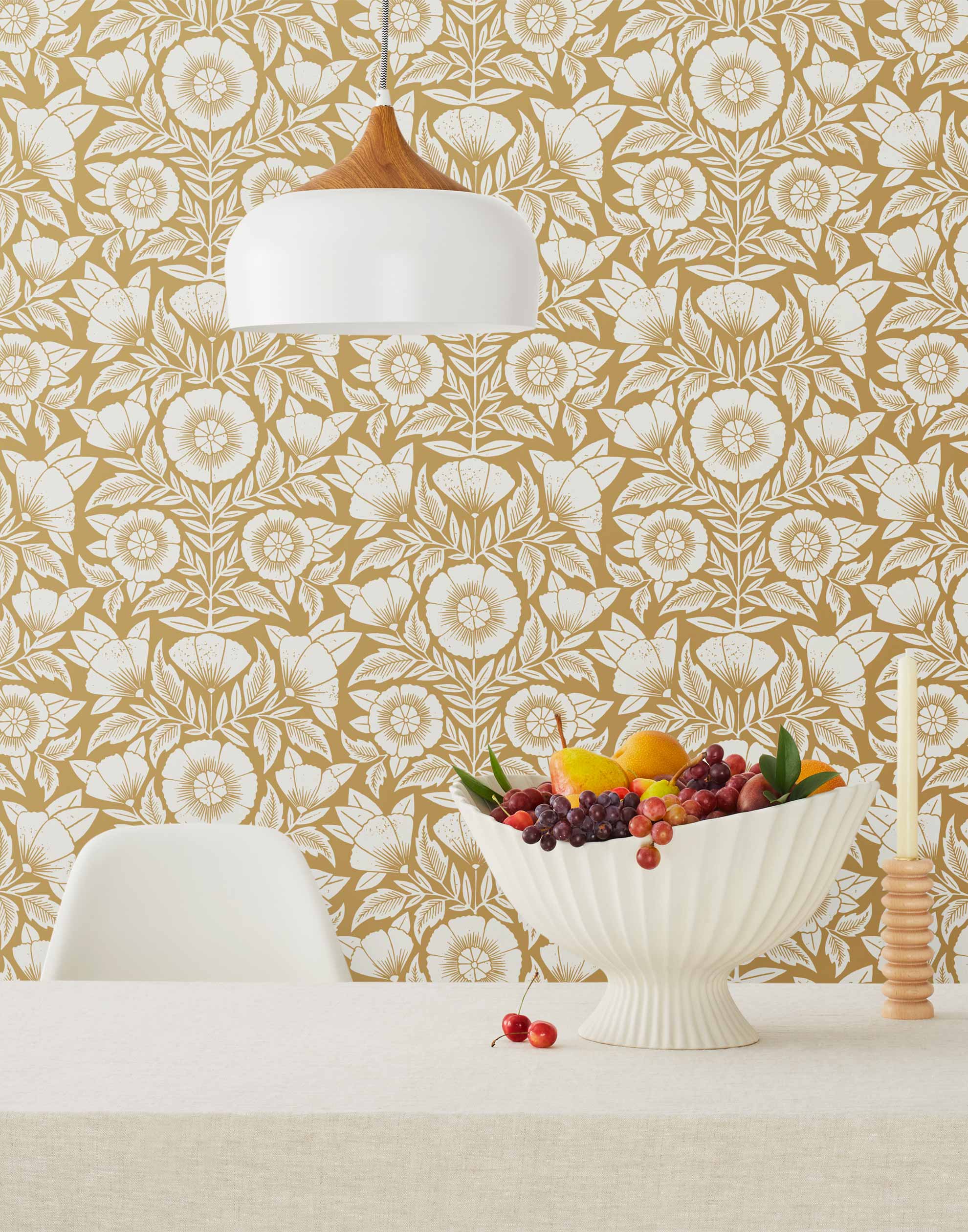 Conservatory wallpaper featuring stylized petals and leaves dervived from a block-print technique was designed by Katharine Watson for Hygge & West. Featuring white flowers on and ochre / yellow mustard wallpaper background.