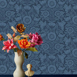 Conservatory wallpaper featuring stylized petals and leaves dervived from a block-print technique was designed by Katharine Watson for Hygge & West. Featuring cornflower blue flowers on a navy blue wallpaper background.