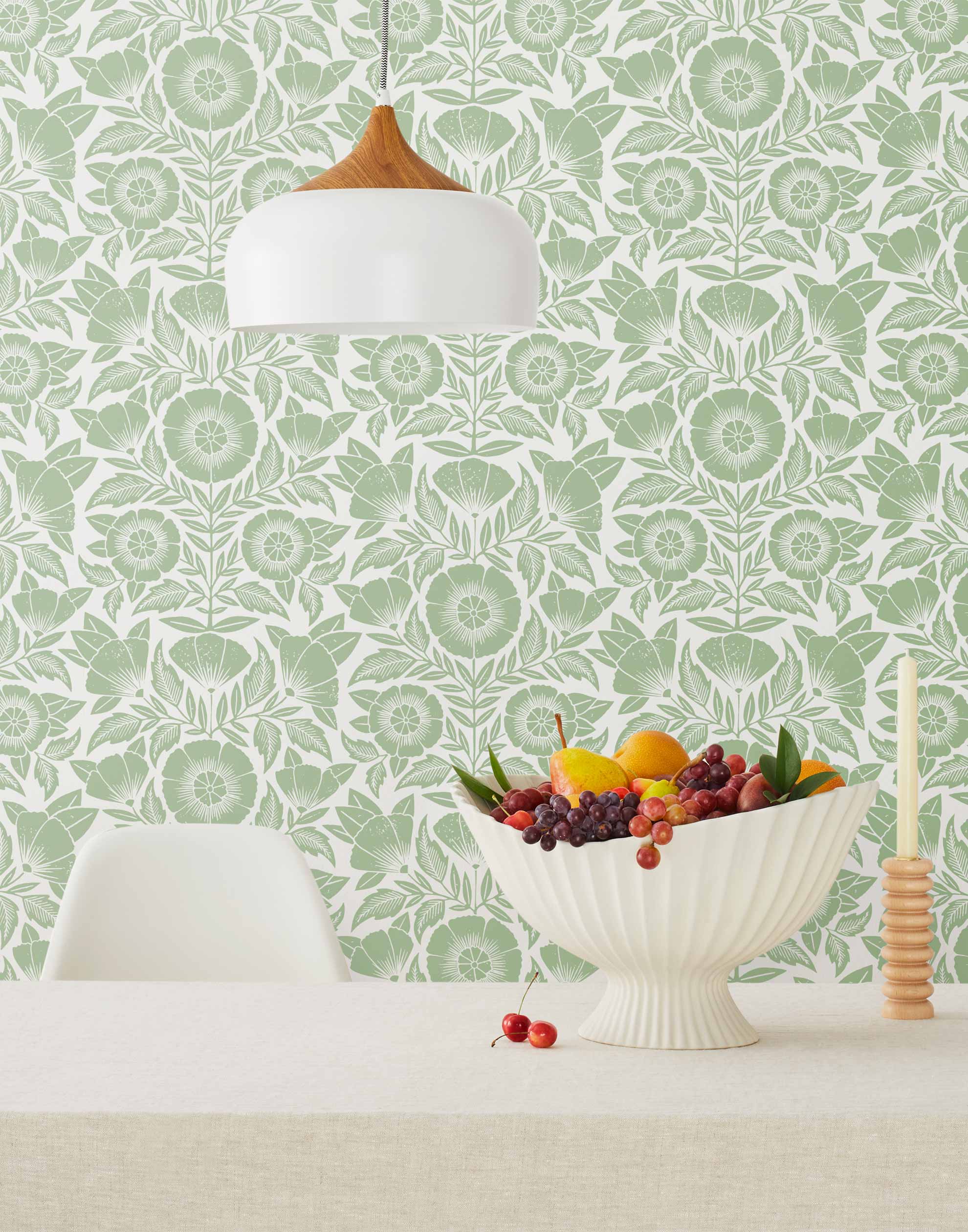 Conservatory wallpaper featuring stylized petals and leaves dervived from a block-print technique was designed by Katharine Watson for Hygge & West. Featuring sage green flowers on a white wallpaper background.