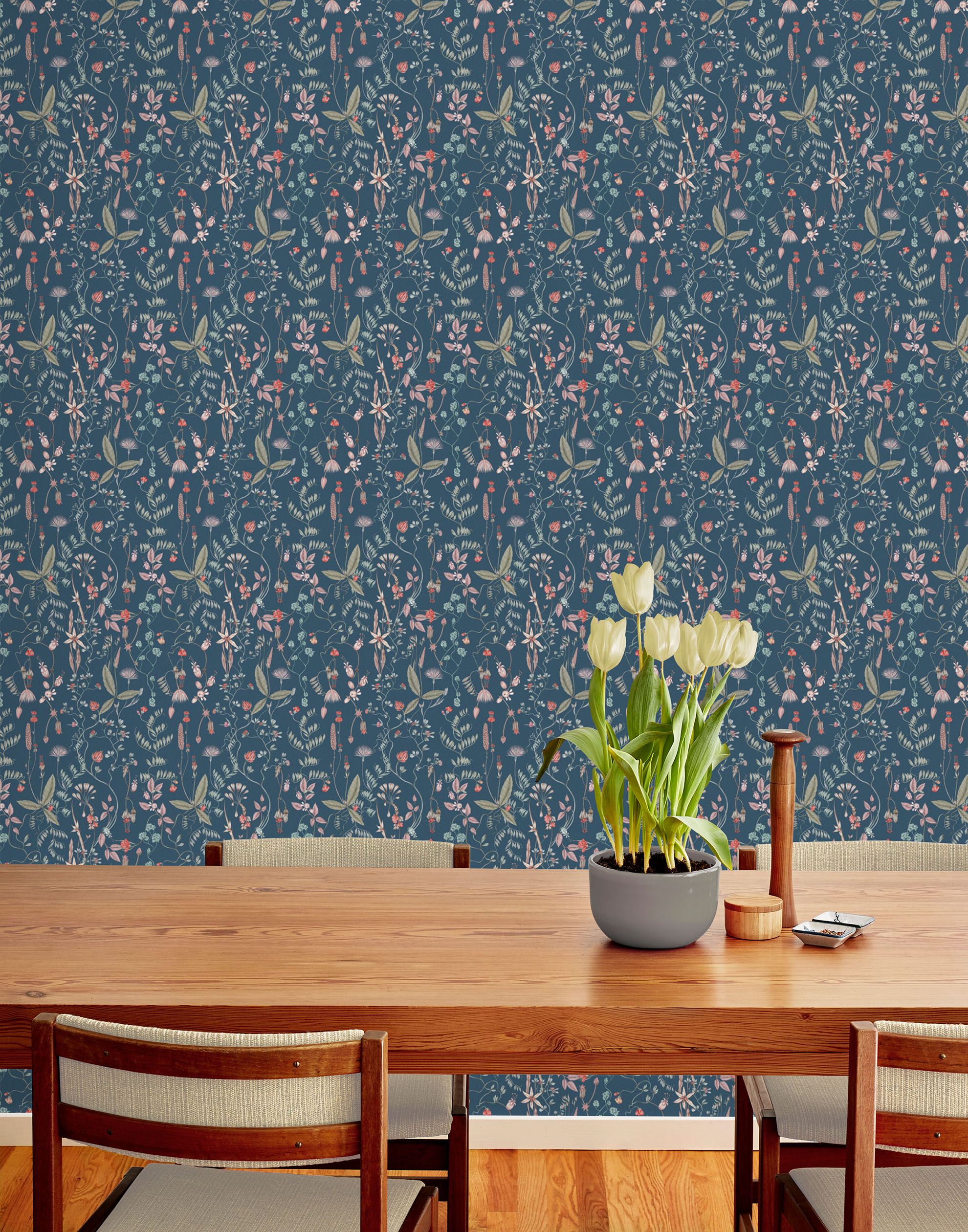Sonoma (Indigo) wallpaper with green, mauve, coral and pink flowers and leaves on a blue background