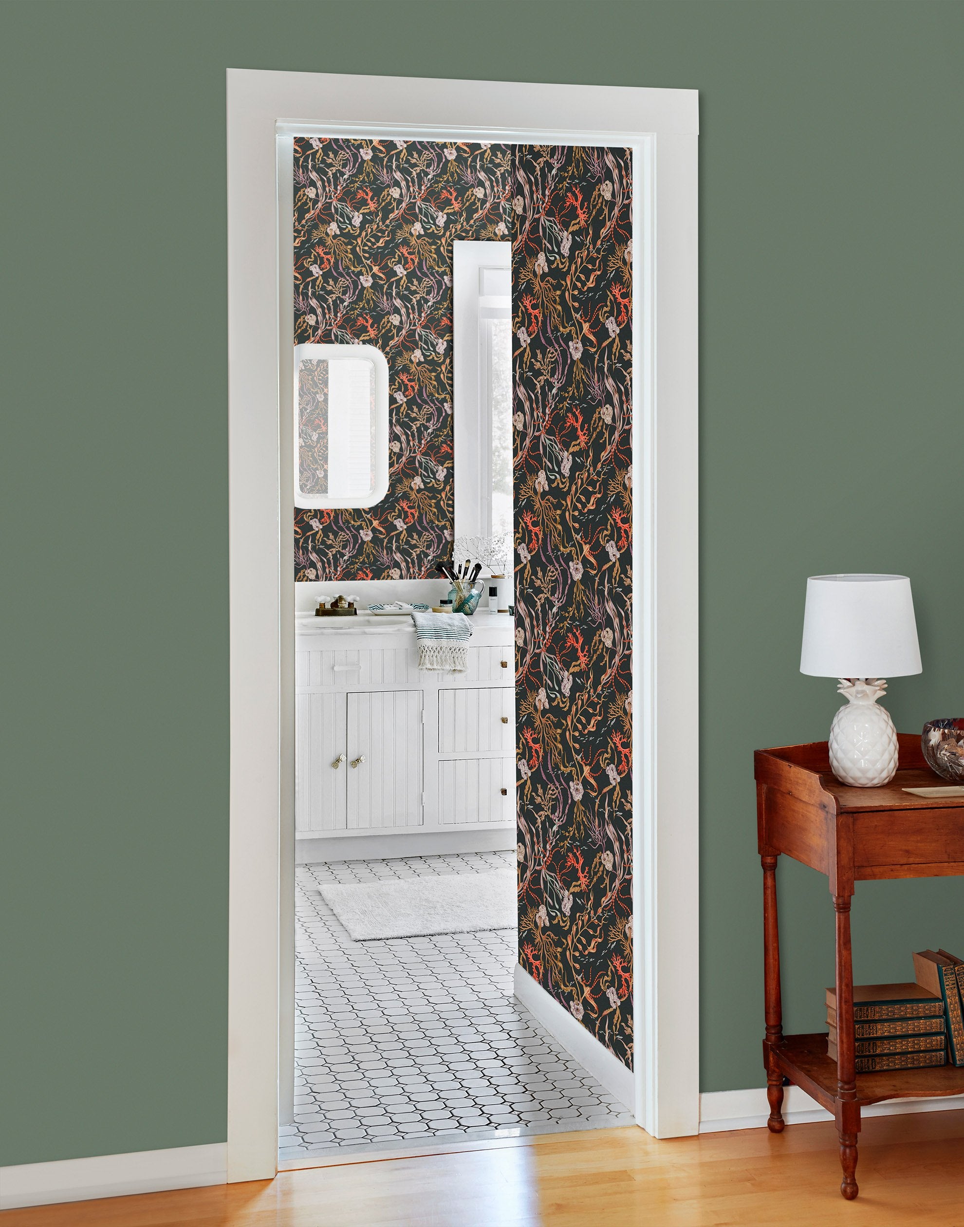Atoll (Coral) wallpaper features shades of orange, purple, brown and green seaweed and coral on a soft black background