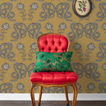 Serpentine (Butterscotch) Wallpaper featuring charcoal and cream snakes and flowers on a golden ochre yellow background