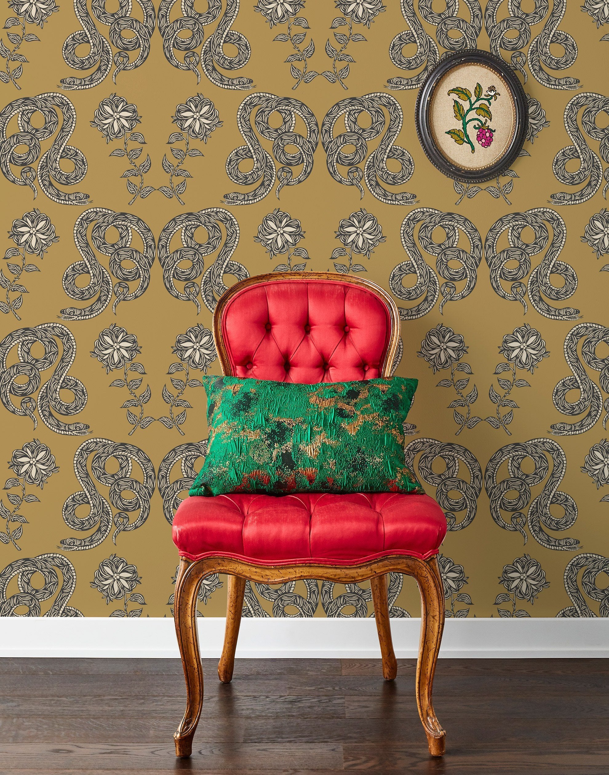 Serpentine (Butterscotch) Wallpaper featuring charcoal and cream snakes and flowers on a golden ochre yellow background