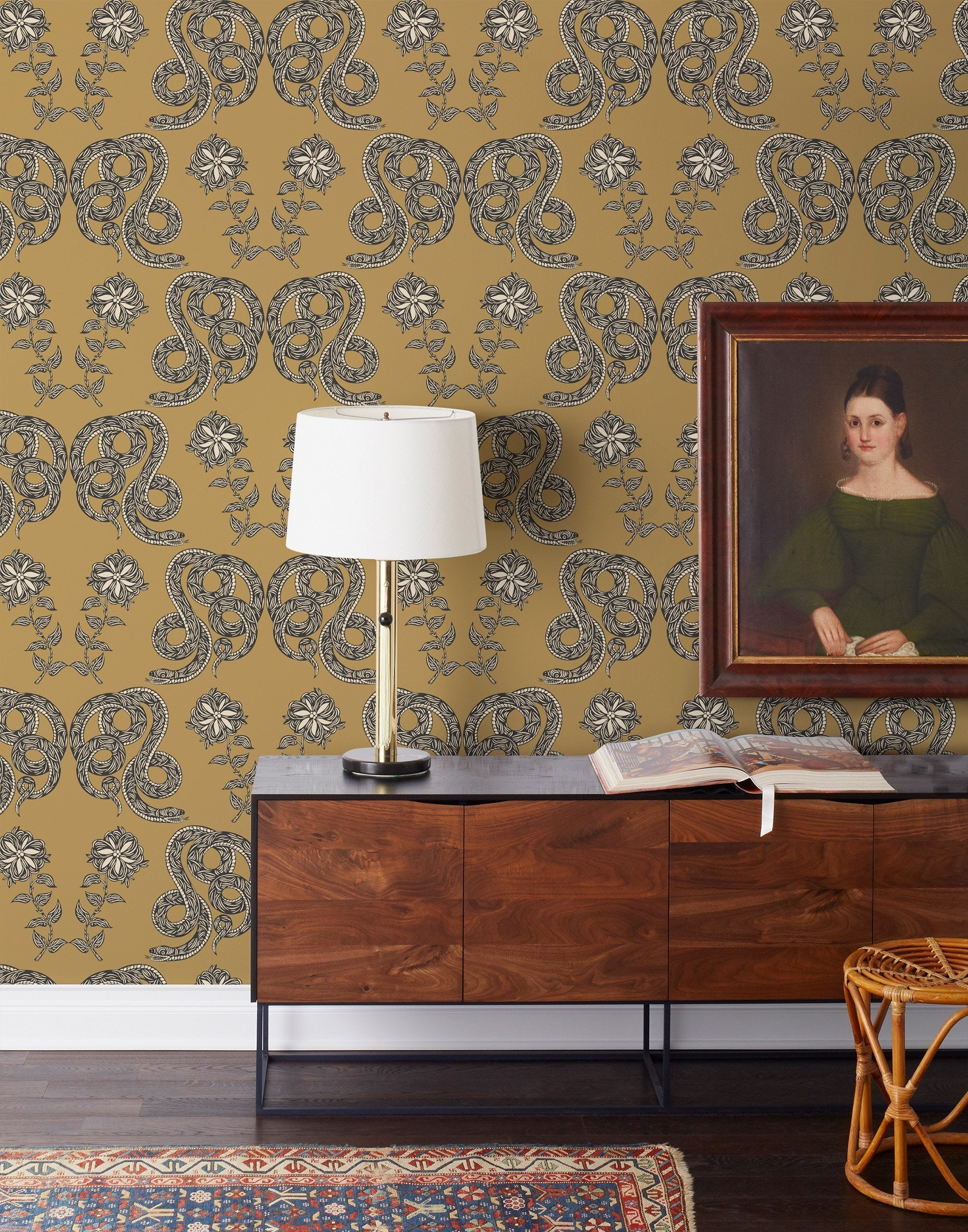 Serpentine (Butterscotch) Wallpaper featuring charcoal and cream snakes and flowers on a golden ochre yellow background