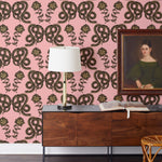 Serpentine (Punch) Wallpaper featuring black and metallic gold snakes and flowers on a punchy pink background