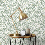 Olive Grove (Spruce) featuring a leafy vine motif in shades of green with pale yellow accents on an off white background | Schoolhouse x Hygge & West Wallpaper Collection