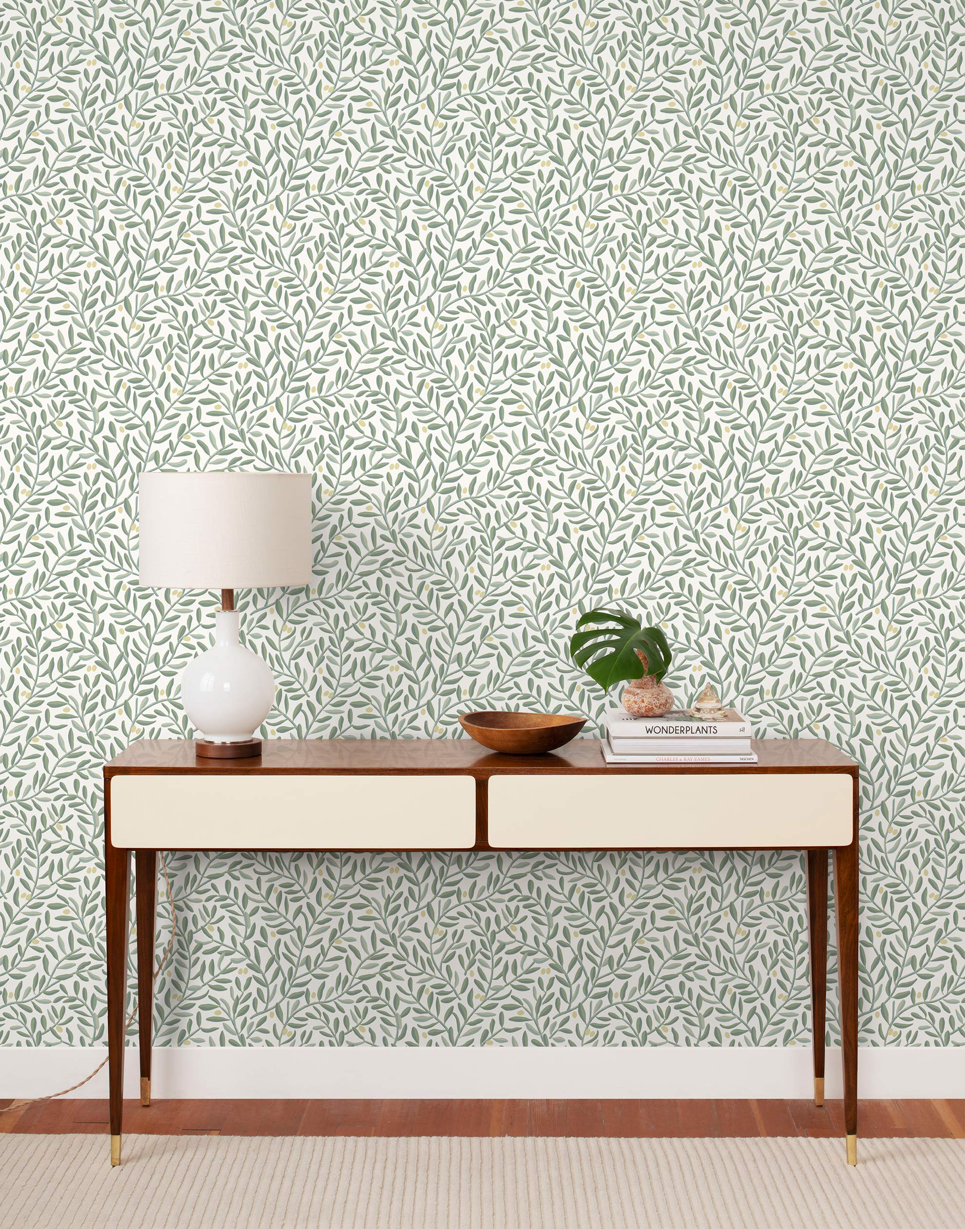 Olive Grove (Spruce) featuring a leafy vine motif in shades of green with pale yellow accents on an off white background | Schoolhouse x Hygge & West Wallpaper Collection