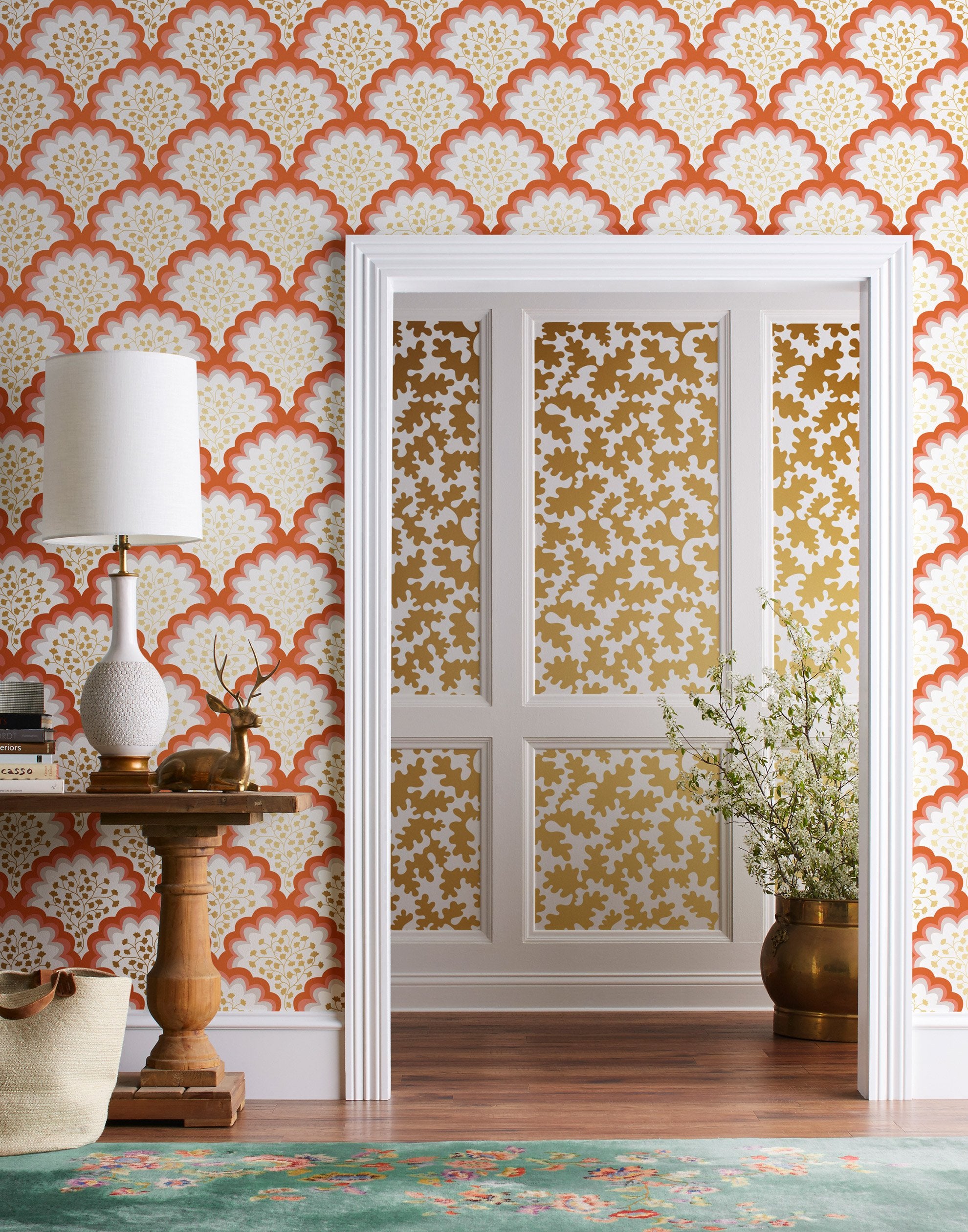 Angelina (Coral) wallpaper features an off white background with graduated coral scallops and gold floral motif