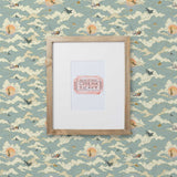 Amity Sunset (Sky) Wallpaper with dusty blue, cream and orange illustrations depicts scenes from the iconic movie Jaws and was created in collaboration with Universal | Hygge & West