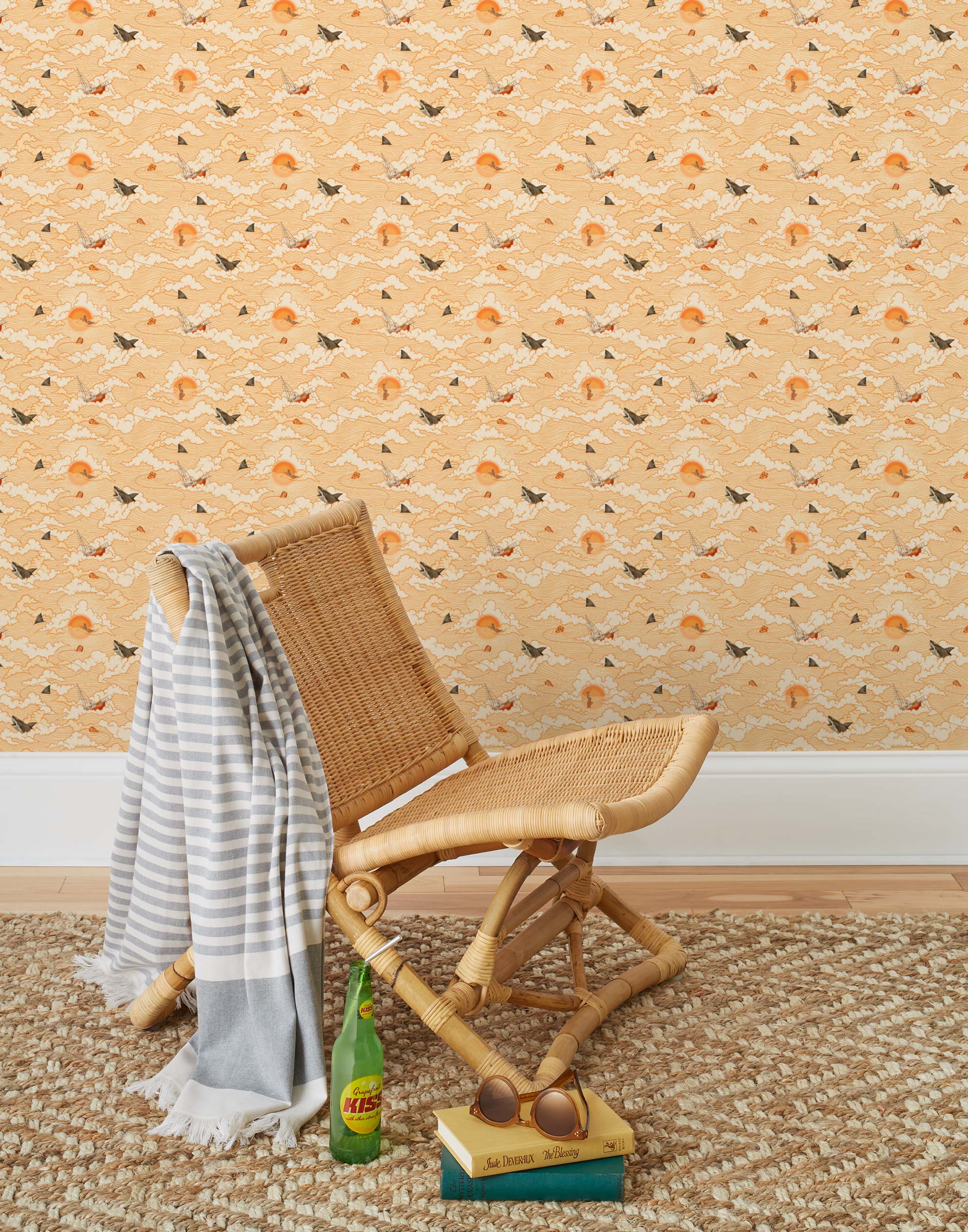 Amity Sunset (Blush) Wallpaper with pink, orange, and white illustrations depicts scenes from the iconic movie Jaws and was created in collaboration with Universal | Hygge & West