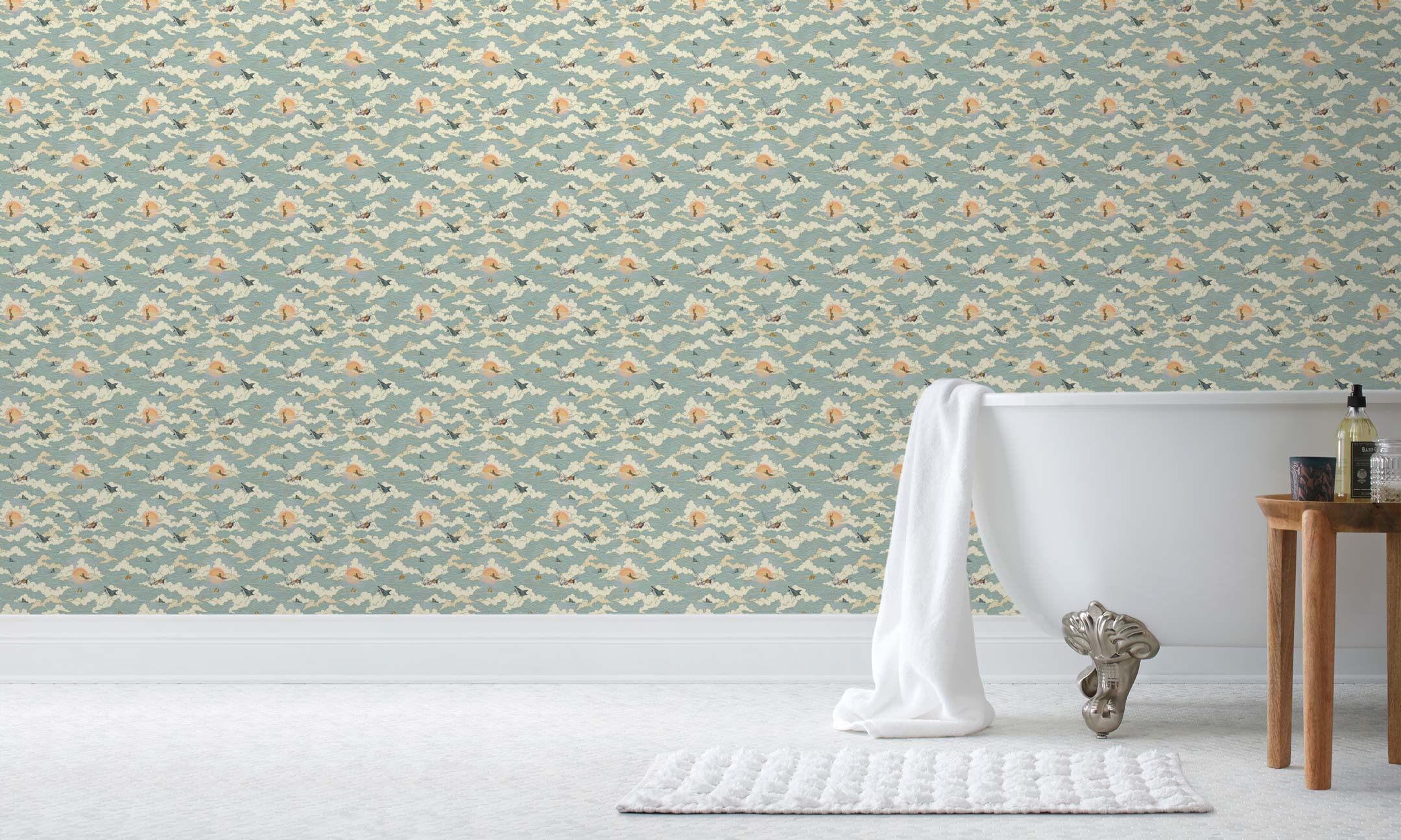Amity Sunset (Sky) Wallpaper with dusty blue, cream and orange illustrations depicts scenes from the iconic movie Jaws and was created in collaboration with Universal | Hygge & West