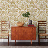Conservatory wallpaper featuring stylized petals and leaves dervived from a block-print technique was designed by Katharine Watson for Hygge & West. Featuring white flowers on an ochre yellow wallpaper background.