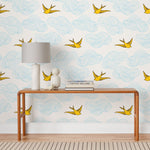 Daydream (Sunshine) features a pattern of flying birds and floating clouds in yellow and blue on white