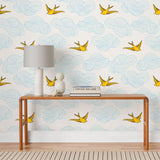 Daydream (Sunshine) features a pattern of flying birds and floating clouds in yellow and blue on white