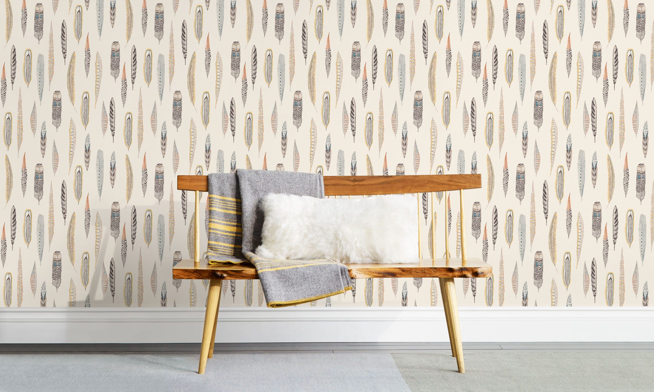 Plumes Natural Wallpaper features delicate feathers in orange, rust, blues and browns on a cream background