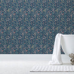 Sonoma (Indigo) wallpaper with green, mauve, coral and pink flowers and leaves on a blue background